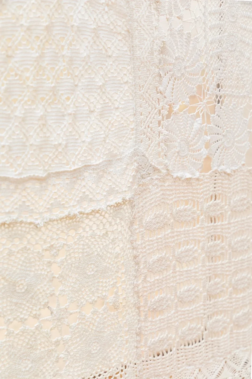 Close detail of overlapping ivory crochet and lace patterns in Hestia
