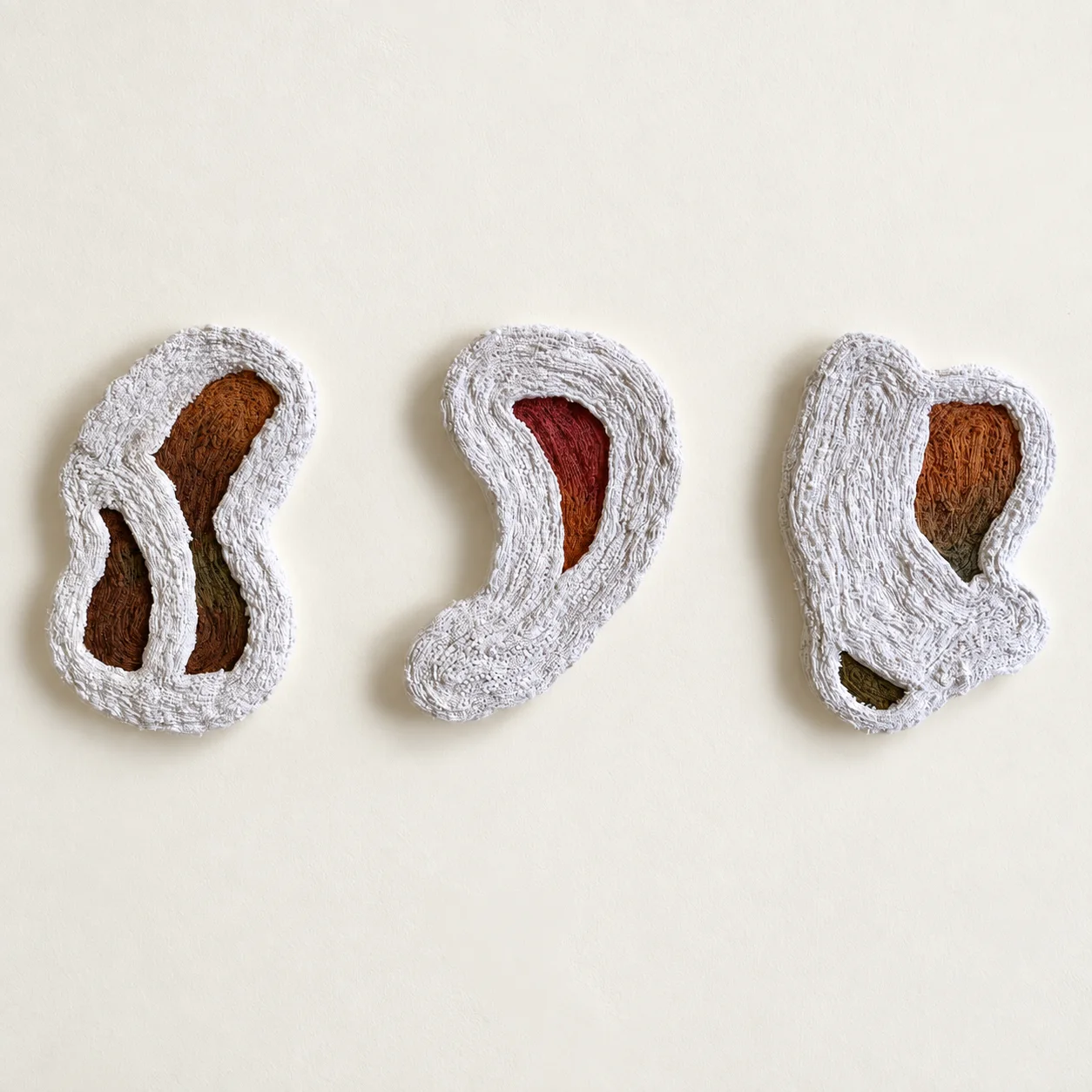 Soft Chamber, Threaded Keep and Silent Cocoon, from left to right: three pale crocheted textile vessels with pigmented interiors
