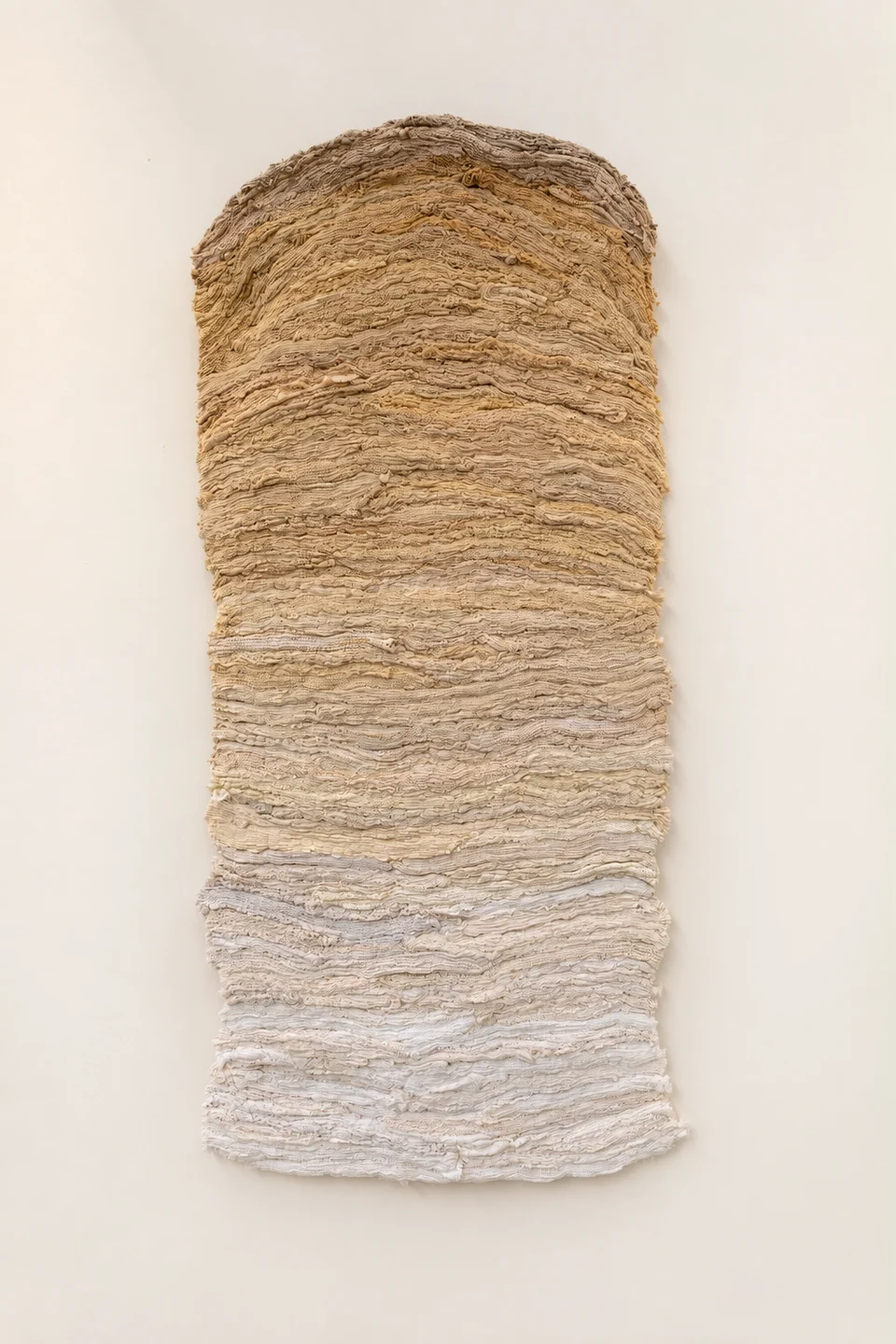 Long wall-mounted textile graduating from warm ochre to ivory
