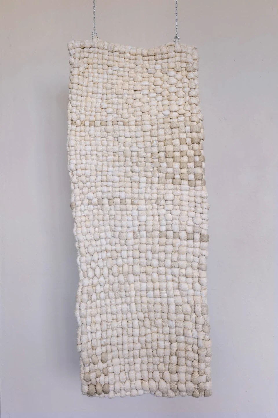 Suspended ivory textile woven from rounded interlocking forms