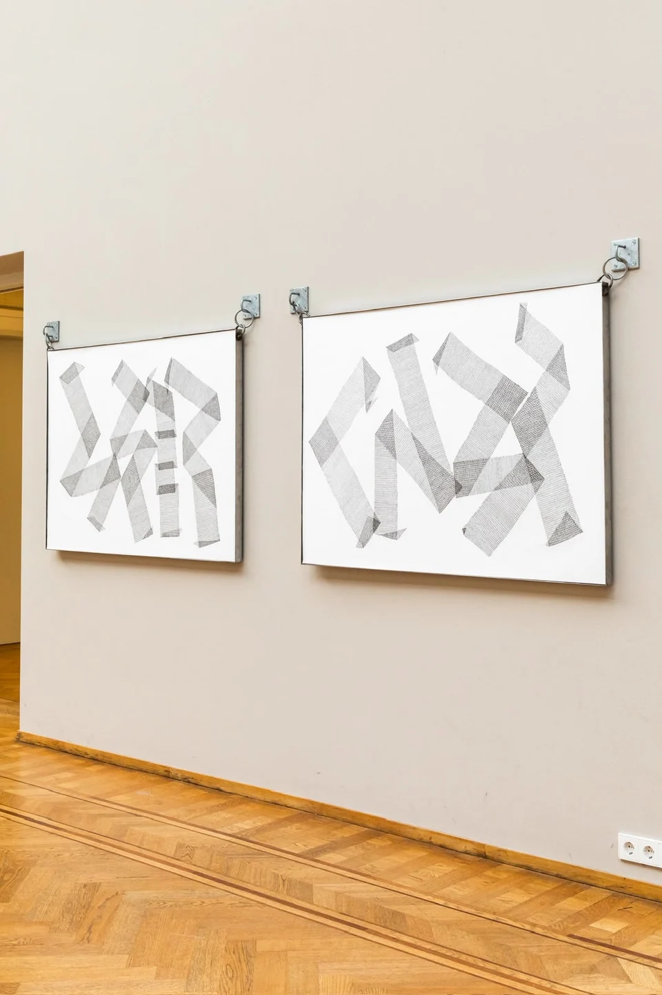 Interlaced by Hara Athanasopoulou, two geometric ink drawings displayed on steel supports in a gallery