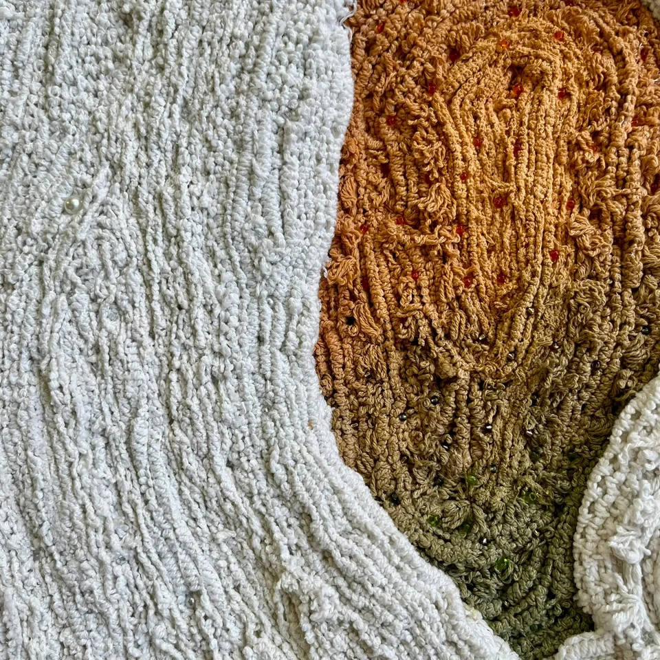 Detail of Silent Cocoon showing white lace, ochre and olive fibres, and beads